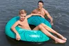A man and a boy are in the water, with the boy sitting in a swim ring. Anteprima dell’immagine prodotto