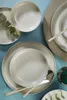 A top-down view of a set of ceramic dishes arranged on a blue surface. Voir les images du produit