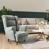 A living room scene with a grey armchair, a beige sofa, and a coffee table with flowers. Náhľad obrázku produktu