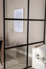 A room divider with a framed abstract art piece on the wall behind it, and a portion of a white sofa in the foreground. Produktbild-Vorschau