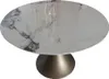 A round dining table with a marble-like ceramic top and a bronze pedestal base, isolated on a white background. Produktbild-Vorschau