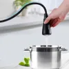 A hand is holding a black kitchen faucet with water running into a stainless steel pot. Náhľad obrázku produktu
