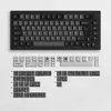 A top-down view of a mechanical keyboard and its keycaps, laid out on a textured light gray surface. Produktbild-Vorschau
