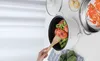 A person is using a wooden spoon to stir food in a white electric pot. There are also cooked crabs and corn on the cob visible in the background. Produktbild-Vorschau