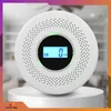 A white carbon monoxide detector is displayed on a pedestal against a blurred background. Podgląd zdjęcia produktu