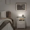 A bedside table with integrated LED lighting next to a bed in a bedroom. Voir les images du produit