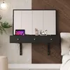 A modern black floating vanity with a mirror, makeup, and a tablet is mounted on a wall with a split design of textured white and wood paneling. Voir les images du produit