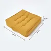 A yellow square cushion is shown from a diagonal angle on a white background, with dimensions indicated by arrows and text. Náhled obrázku produktu