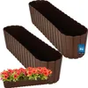 Two brown plastic planters are shown against a white background. One planter is in the foreground, and the other is behind it and slightly to the right. A small planter filled with red flowers is placed in front of the foreground planter. Náhľad obrázku produktu