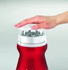 A hand is pressing the lid of a red coffee grinder. Náhľad obrázku produktu