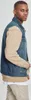 A man wearing a denim vest with beige sleeves. Produktbild-Vorschau