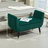 A green upholstered bench with storage is placed in a bedroom setting next to a bed. Náhled obrázku produktu