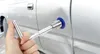 A hand is using a tool to remove a dent from a car door. Produktbild-Vorschau