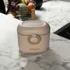 A beige Babyono portable milk powder container with a white scoop in front of it, placed on a marble countertop. Produktbild-Vorschau