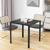 A square black glass-top dining table with two chairs in a room with light wood flooring and a grey curtain. Produktbild-Vorschau