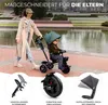 A woman pushing a child on a green tricycle next to a body of water. Produktbild-Vorschau