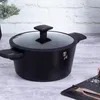 A black pot with a glass lid sits on a wooden table. Podgląd zdjęcia produktu