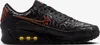 A side view of a black Nike Air Max 90 sneaker with orange accents and yellow visible air units. Anteprima dell’immagine prodotto