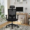 An office chair is placed in a home office setting next to a desk with a computer and lamp. Produktbild-Vorschau