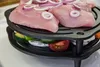 A close-up shot of a multi-level grill with raw meat and vegetables. Produktbild-Vorschau
