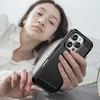 A person is lying in bed, holding a black phone case. Podgląd zdjęcia produktu