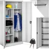 An open metal storage cabinet with various items inside, including clothing, a hard hat, and a water bottle. A key is shown in the foreground. Produktbild-Vorschau