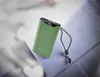 A green power bank with a digital display showing '90%' is placed on a textured surface. Voir les images du produit