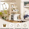A multi-level cat shelf unit with a cat house at the bottom, placed in a living room setting next to a sofa. The image includes text overlays and icons highlighting product features. Produktbild-Vorschau