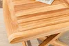 A close-up view of a wooden side table with a slatted top and folding legs. Produktbild-Vorschau