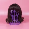 A brown wig on a purple wig stand against a pink background. Produktbild-Vorschau