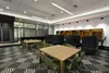 A modern office or co-working space with tables, chairs, and booth seating. Produktbild-Vorschau