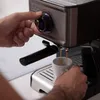 A person's hands are operating a Black+Decker espresso machine, making coffee. Produktbild-Vorschau