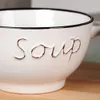 A close-up of a white ceramic soup bowl with the word "Soup" embossed on it. Produktbild-Vorschau