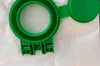 A close-up view of a green plastic vacuum cleaner accessory, likely a dust bag holder or adapter, placed on a white textured surface. Produktbild-Vorschau