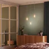 A bedroom scene with a pendant light fixture hanging above a wooden cabinet. Produktbild-Vorschau
