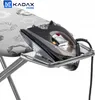 A close-up shot of a black iron resting on a silver ironing board tray. Produktbild-Vorschau