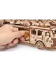 A hand is shown inserting a wooden piece into a wooden fire truck model. Náhľad obrázku produktu