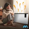A woman is sitting on the floor next to a white electric heater, wrapped in a cozy sweater, with orange heat waves emanating from the heater. Voir les images du produit