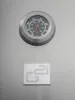 A close-up of a thermometer and a logo on a metallic surface. Náhled obrázku produktu