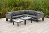 An outdoor sectional sofa with two coffee tables on a patio, surrounded by greenery. Produktbild-Vorschau