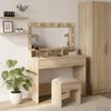 A makeup vanity with a lighted mirror, stool, and a wardrobe in a room. Voir les images du produit