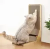 A cat is scratching a cardboard scratching post that is placed in a corner of a room. Voir les images du produit