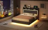 A modern bedroom at night with a city view from the window. The bed is the central focus, illuminated by LED lights. Náhľad obrázku produktu