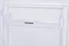 A close-up view of a clear plastic shelf inside a white refrigerator. Produktbild-Vorschau