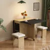 A compact dining set with a foldable table and four stools, set up in a corner of a room with a plant and curtains. Produktbild-Vorschau