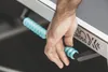 A hand is shown adjusting a blue roller on a table tennis table. Produktbild-Vorschau