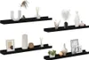 Four black wall shelves are displayed against a white background, each decorated with various decorative items such as vases, picture frames, and diffusers. Podgląd zdjęcia produktu