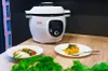 A Tefal Cook4me+ smart multi-function pot is shown on a wooden table with two plates of food in front of it. Podgląd zdjęcia produktu