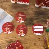 Christmas gift tags and packaging on a wooden table. Produktbild-Vorschau