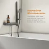 A shower system with a hand shower and a bathtub spout is shown mounted on a wall above a bathtub. A bottle of soap is on a shelf. Podgląd zdjęcia produktu